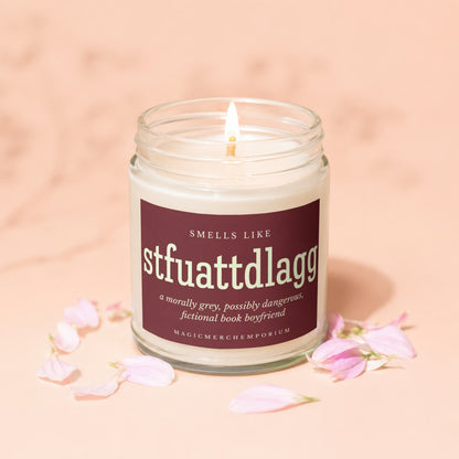 Lit candle in glass jar with label: "Smells Like stfuattdlagg, a morally grey, possibly dangerous, fictional book boyfriend."