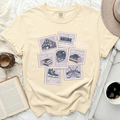 Cream t-shirt with postage stamps featuring hockey imagery and text.