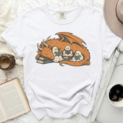 White t-shirt with orange dragon, ghosts reading books, and Halloween pumpkin graphic.