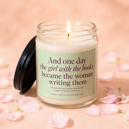 Lit candle in glass jar with the text "And one day the girl with the books became the woman writing them".