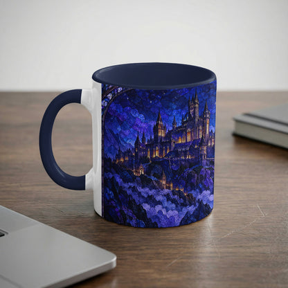 A ceramic mug with a blue rim and handle featuring a stained glass castle illustration against a night sky.
