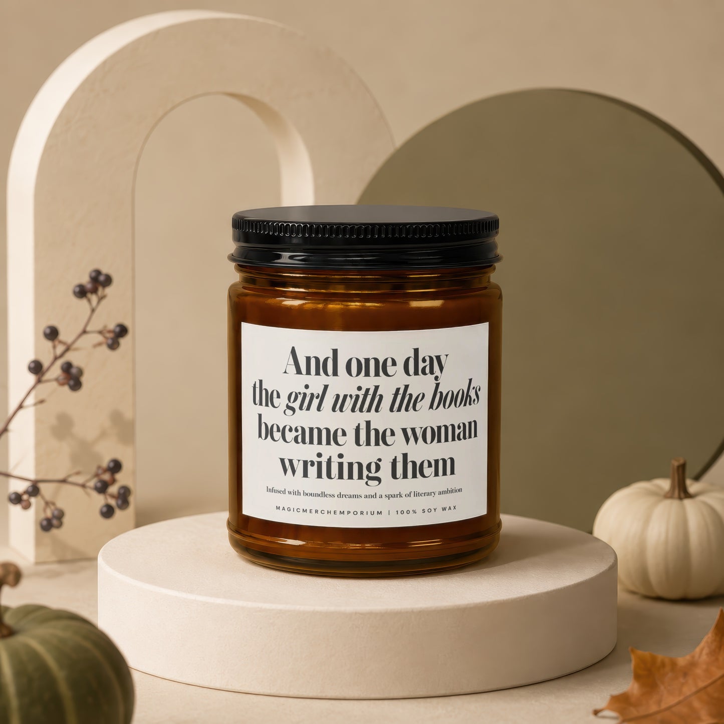 Amber candle with black lid reads "And one day the girl with the books became the woman writing them."