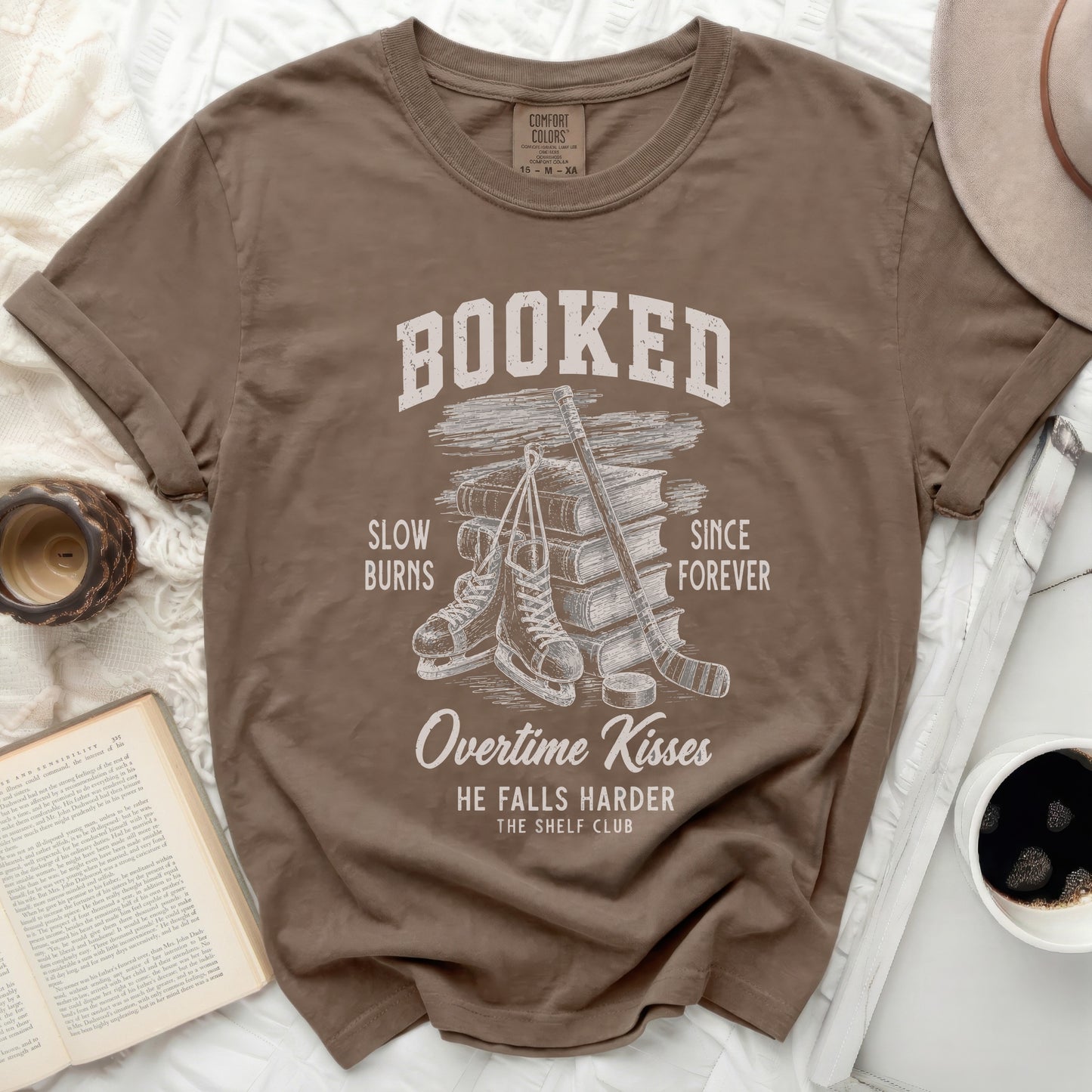 T-shirt with "Booked" text, ice skates, and stacked books.