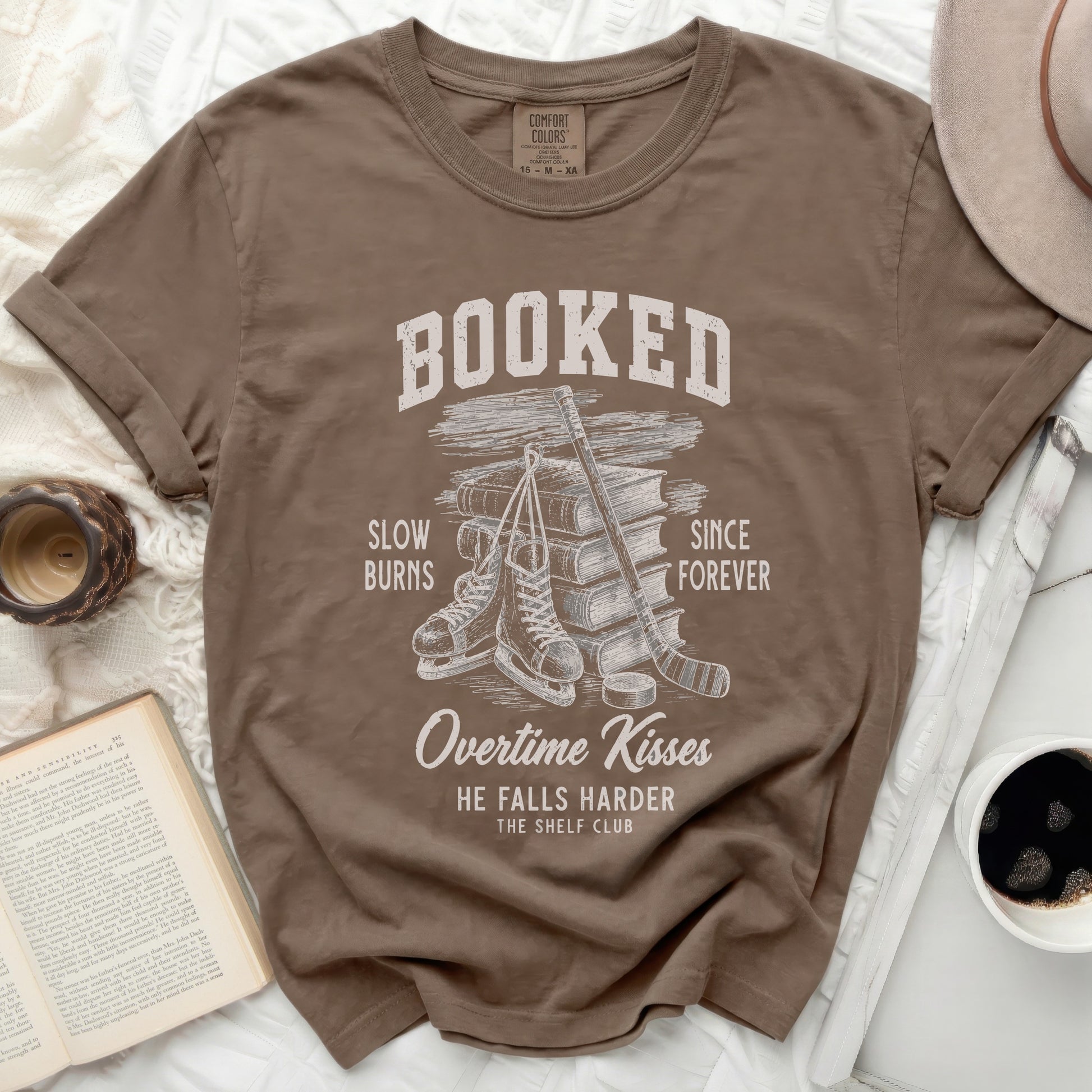 T-shirt with "Booked" text, ice skates, and stacked books.