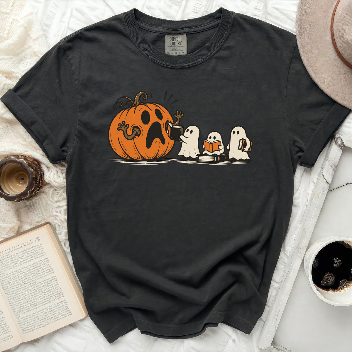 Black t-shirt with cartoon pumpkin and ghosts reading books graphic.