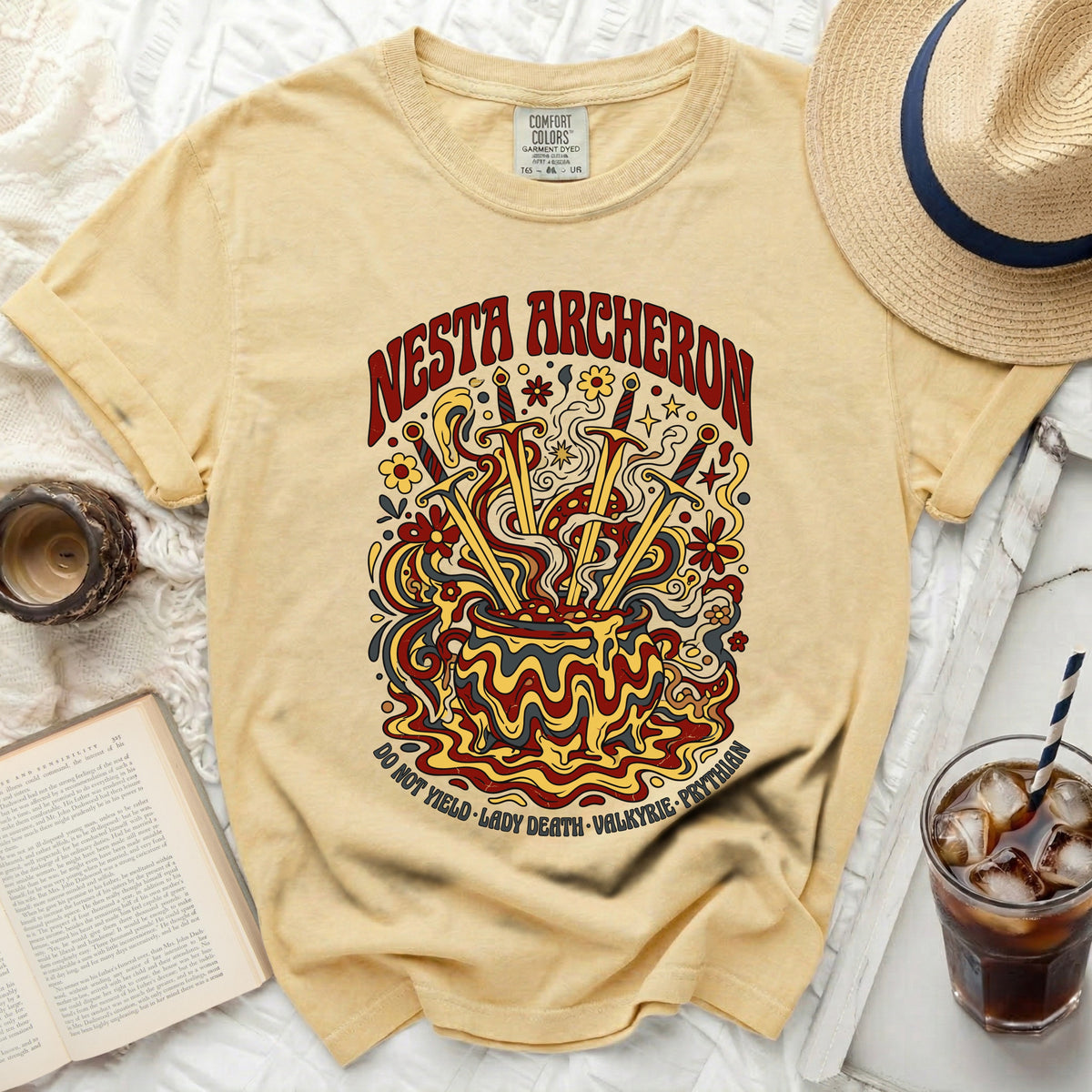 Yellow t-shirt with "Nesta Archerson" and psychedelic cauldron graphic.