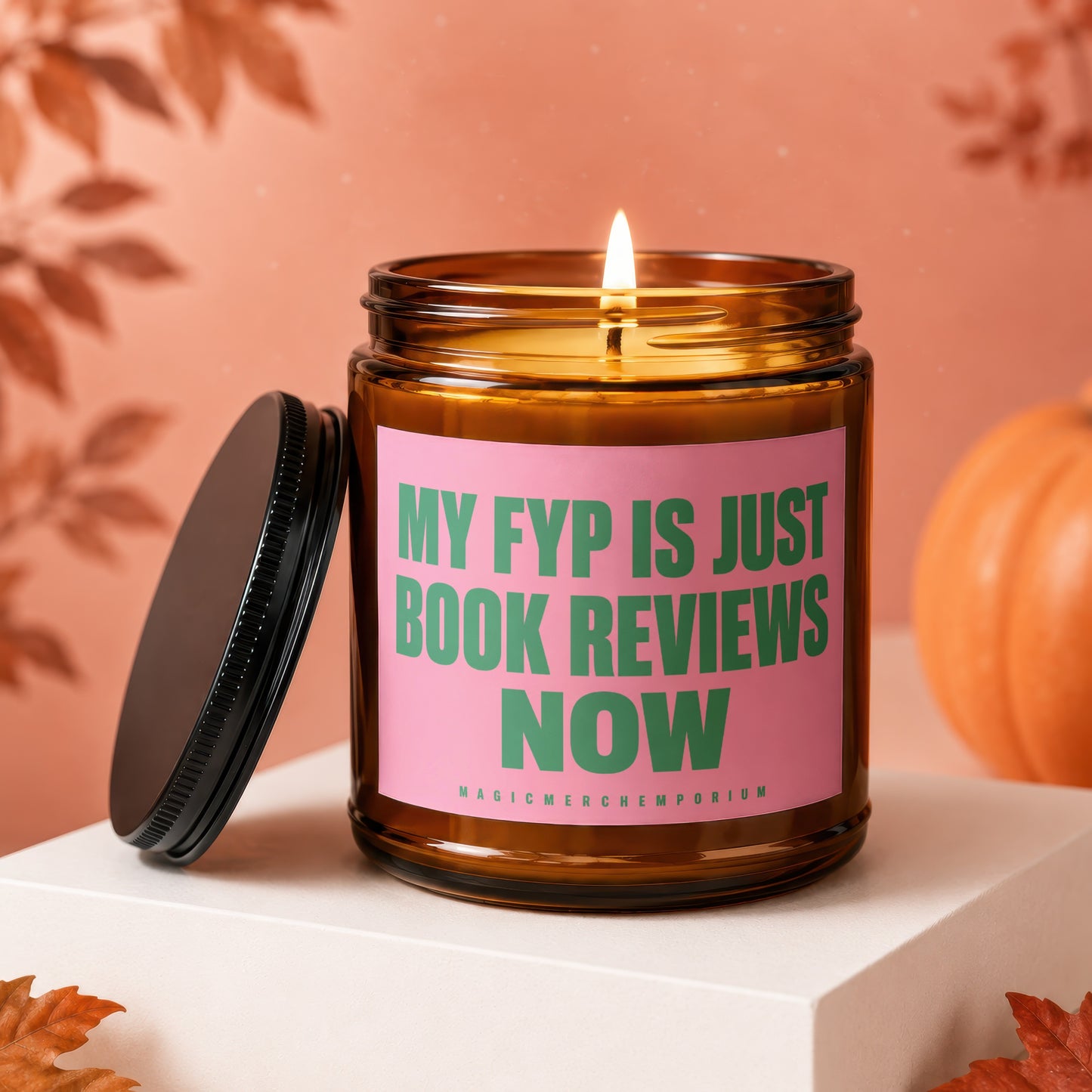 Amber jar candle with pink label reading "MY FYP IS JUST BOOK REVIEWS NOW".