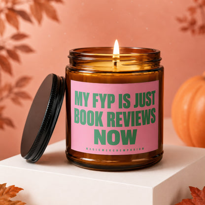 Amber jar candle with pink label reading "MY FYP IS JUST BOOK REVIEWS NOW".