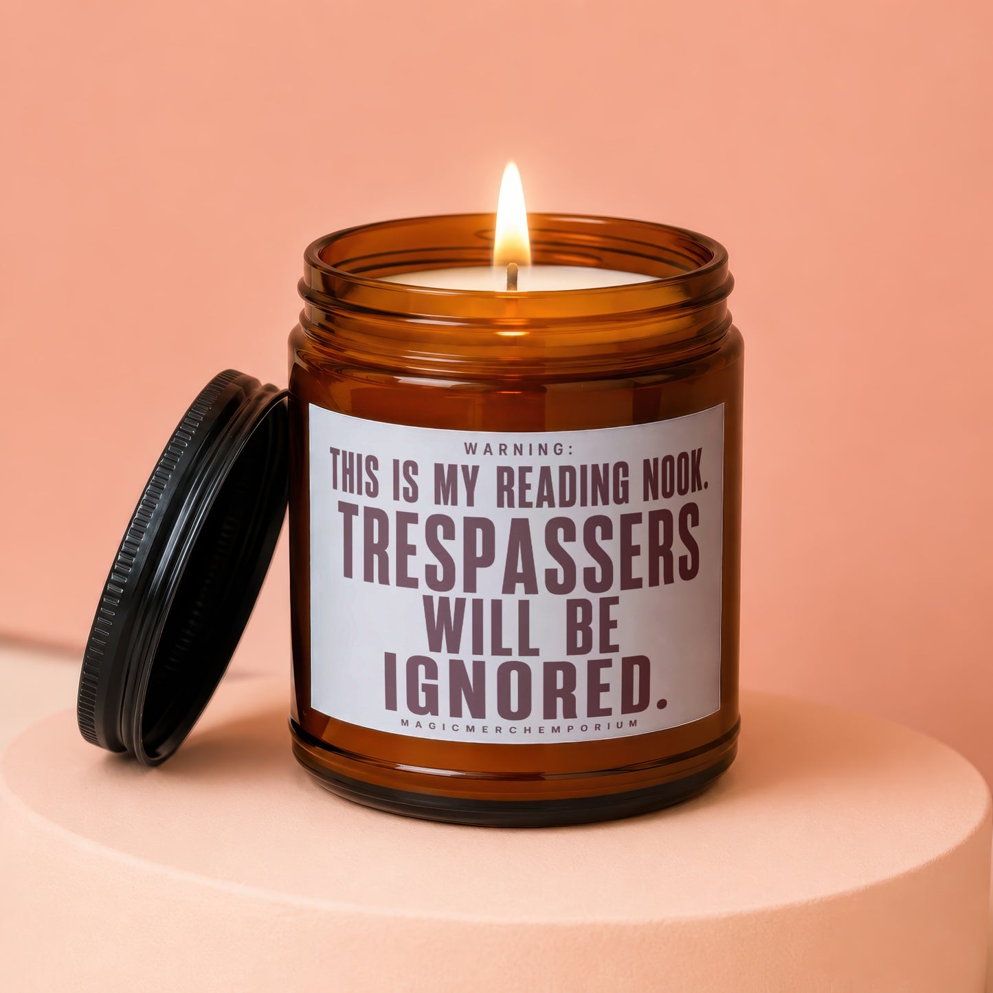 Amber jar candle with lit wick and lid removed, text reads "WARNING: THIS IS MY READING NOOK. TRESPASSERS WILL BE IGNORED."