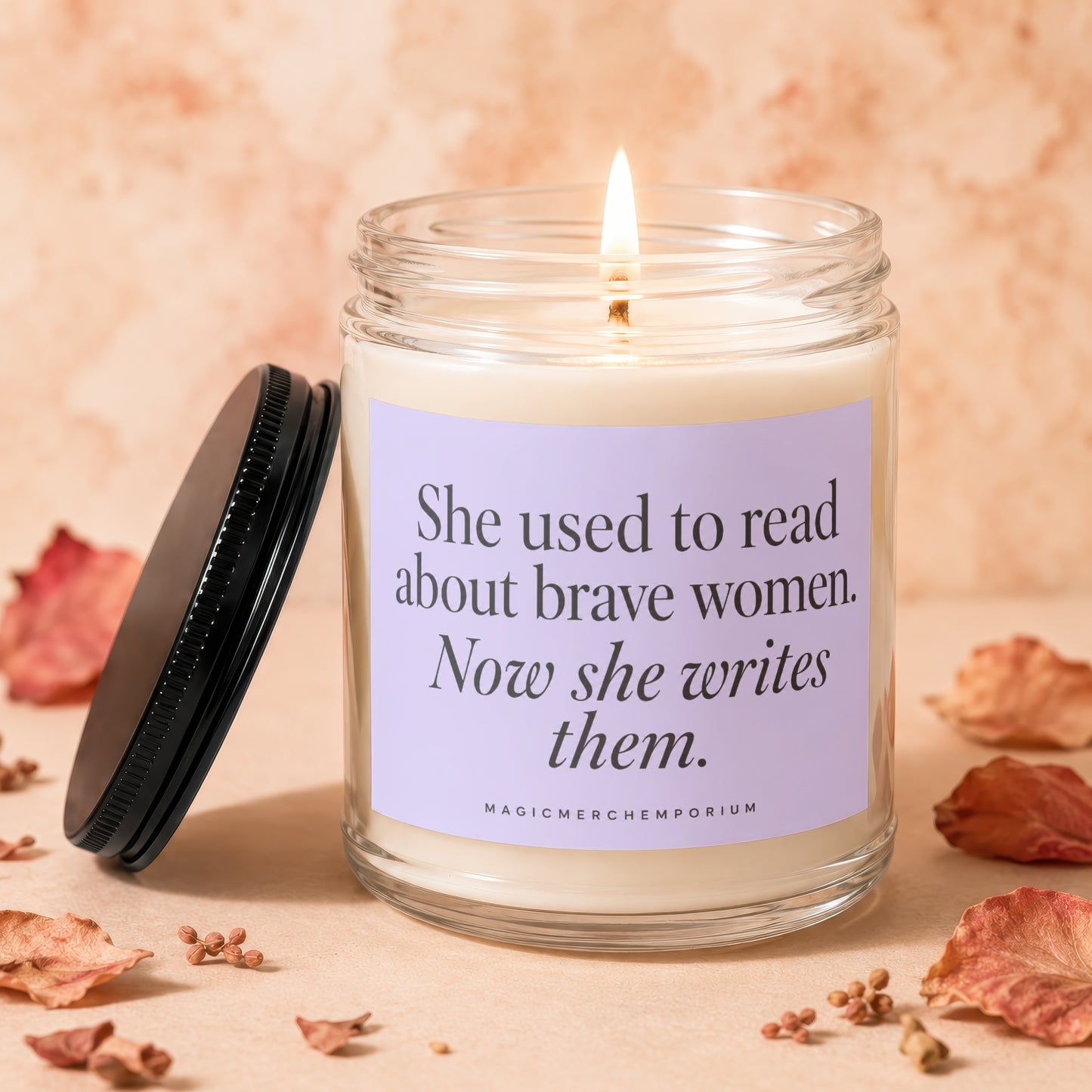 Candle with text "She used to read about brave women. Now she writes them."