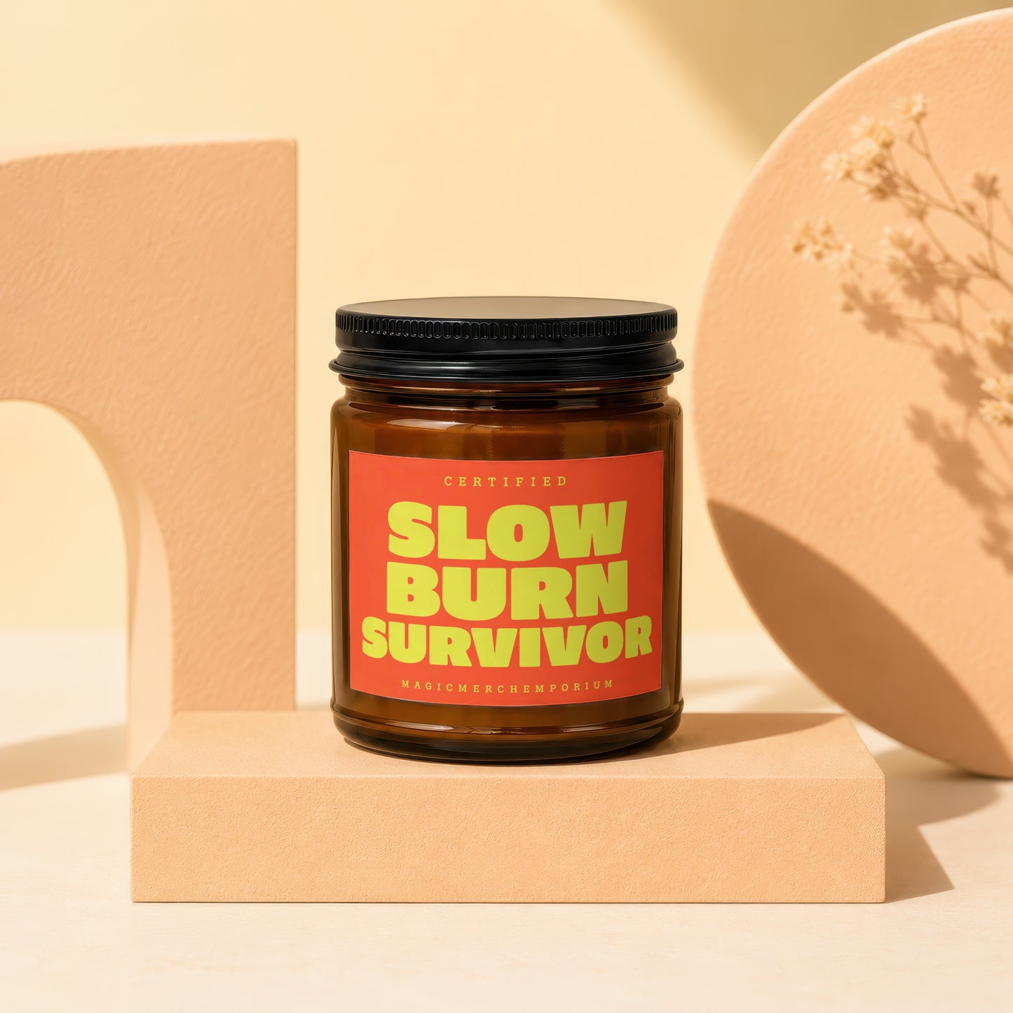 Amber jar candle with a red label reading "CERTIFIED SLOW BURN SURVIVOR MAGICMERCH...EMPORIUM".