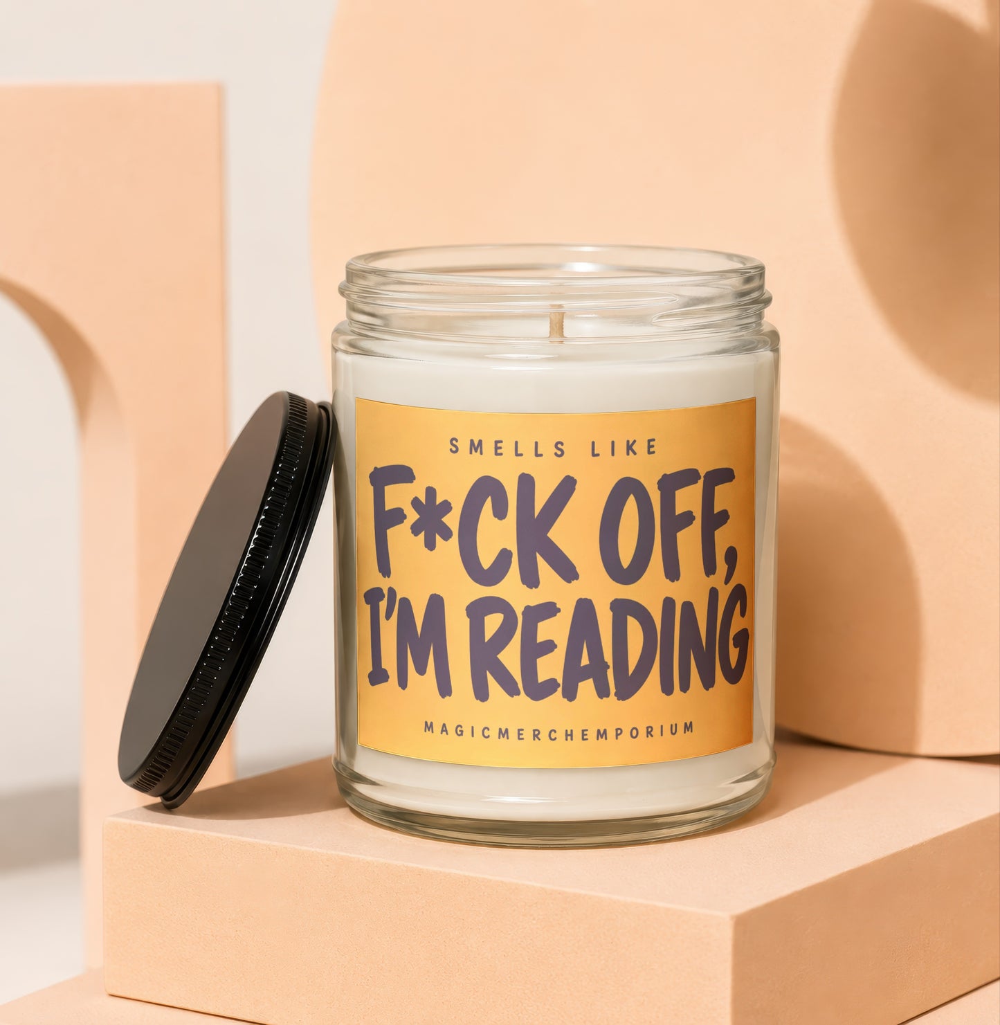 Glass candle with black lid, reads "Smells Like F*ck Off, I'm Reading".