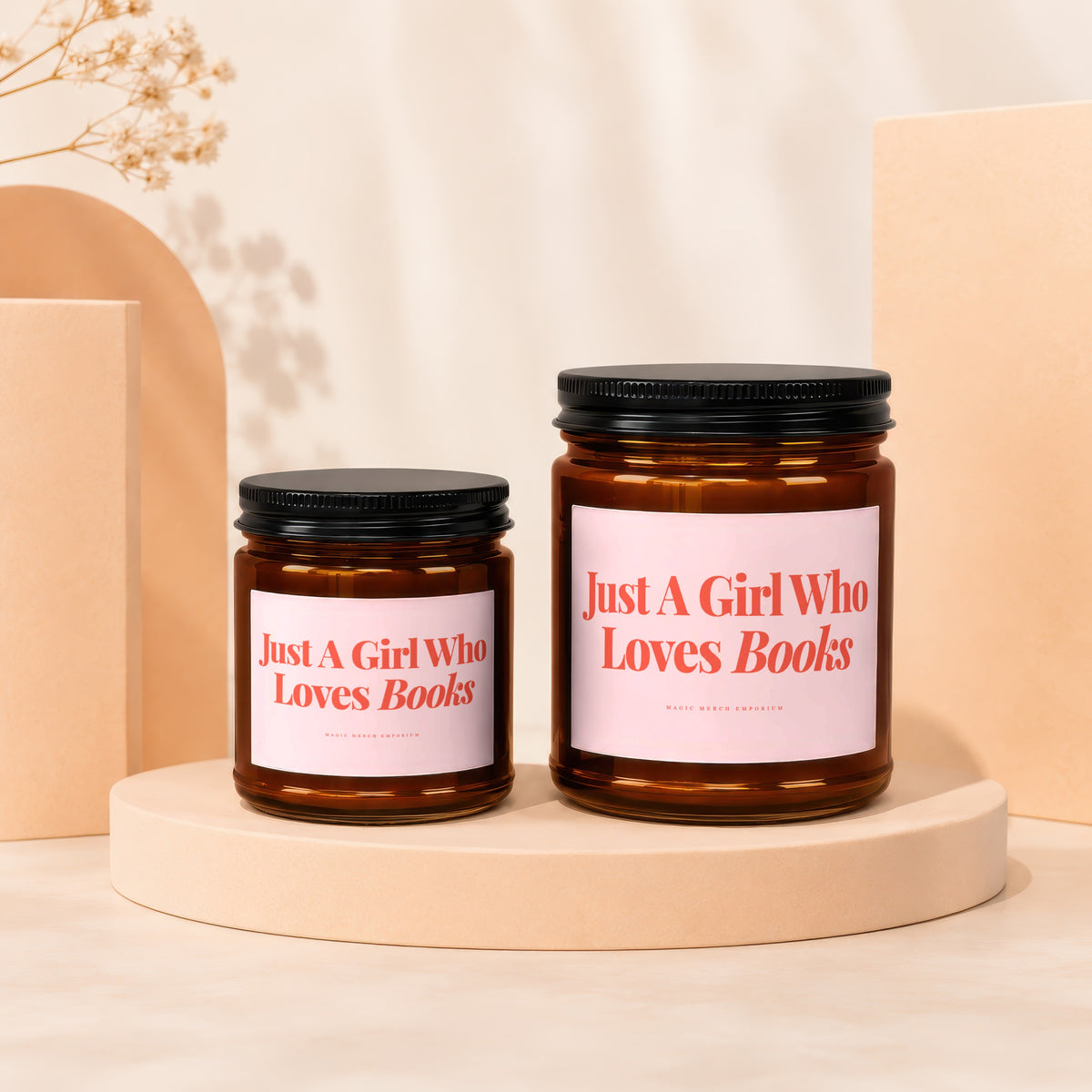 Two amber glass candles with black lids feature pink labels saying "Just A Girl Who Loves Books."