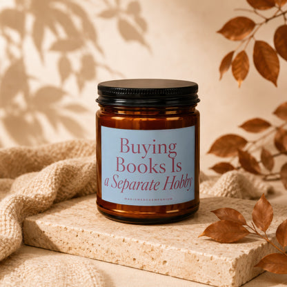 Amber candle with black lid and "Buying Books Is a Separate Hobby" label.