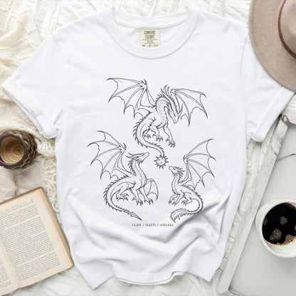 White t-shirt with three black line drawing dragons and text TAIRN / SGAEYL / ANDARNA.