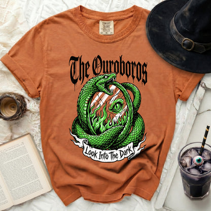 Orange t-shirt with "The Ouroboros" and snake graphic that says "Look Into The Dark".