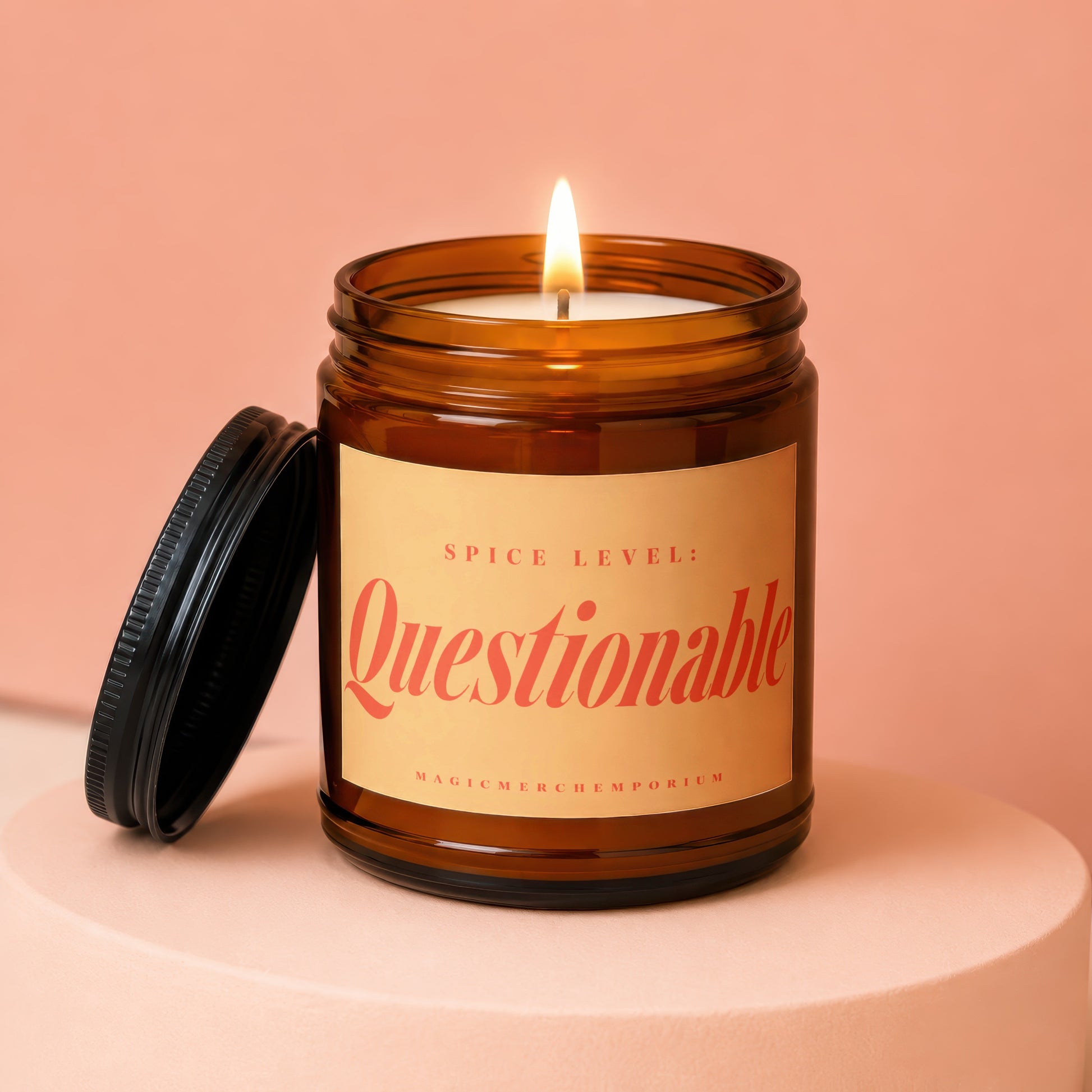 Amber jar candle with lit wick, "Spice Level: Questionable" on label.