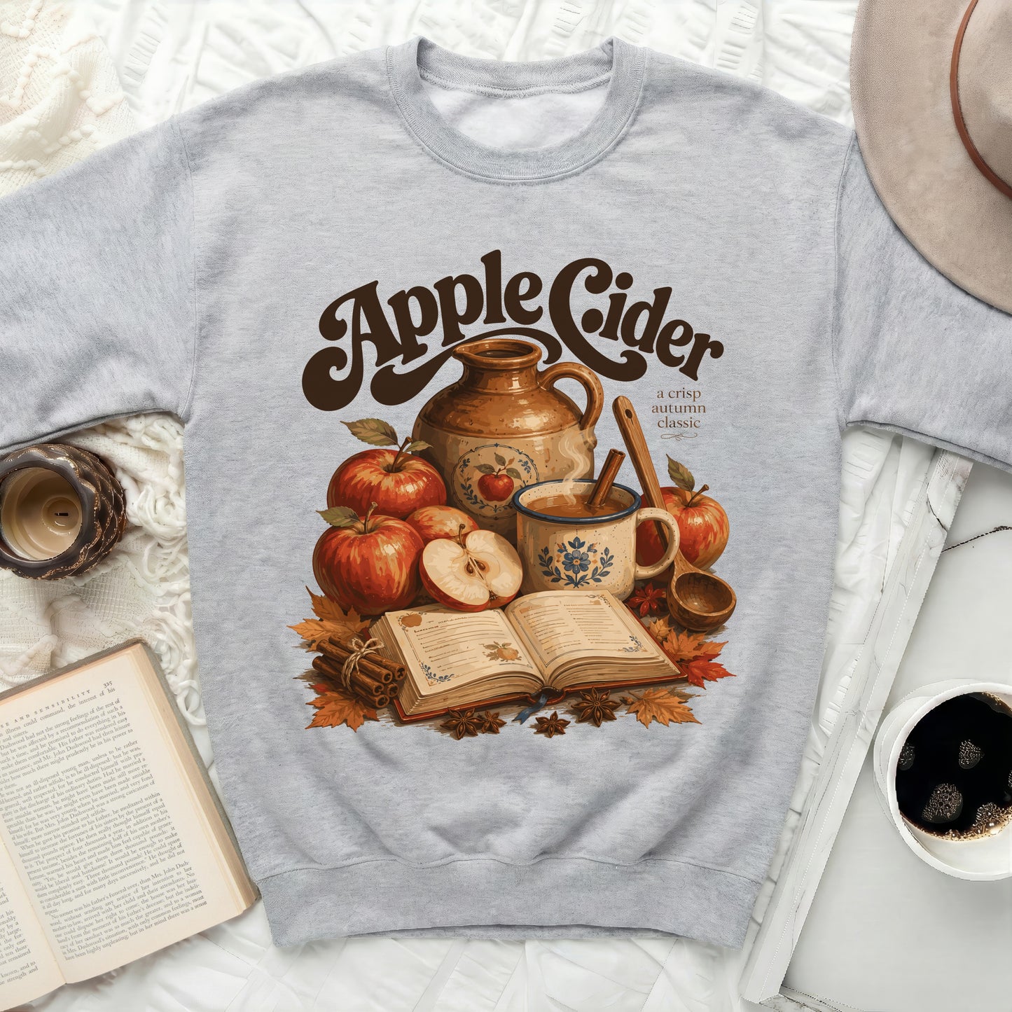 Grey sweatshirt with "Apple Cider a crisp autumn classic" graphic.