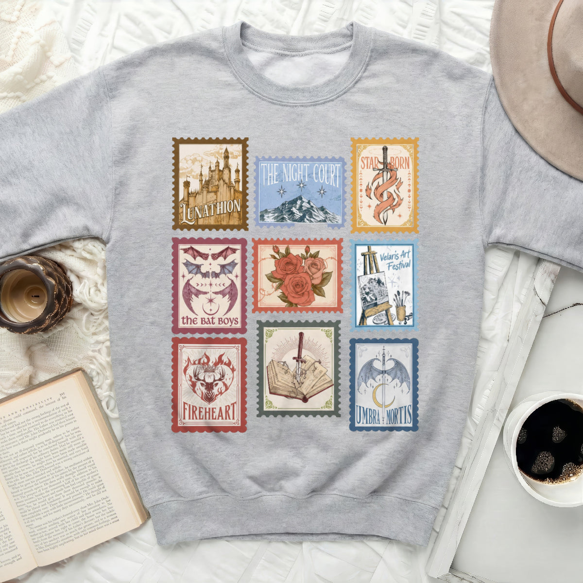 Grey sweatshirt with nine fantasy book-themed postage stamps.