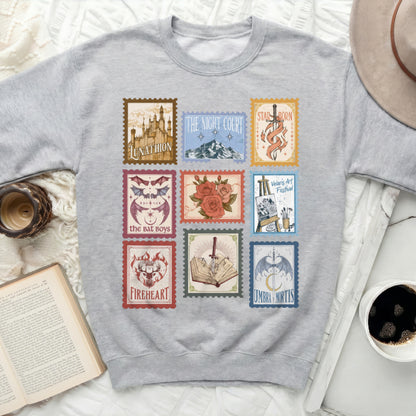 Grey sweatshirt with nine fantasy book-themed postage stamps.