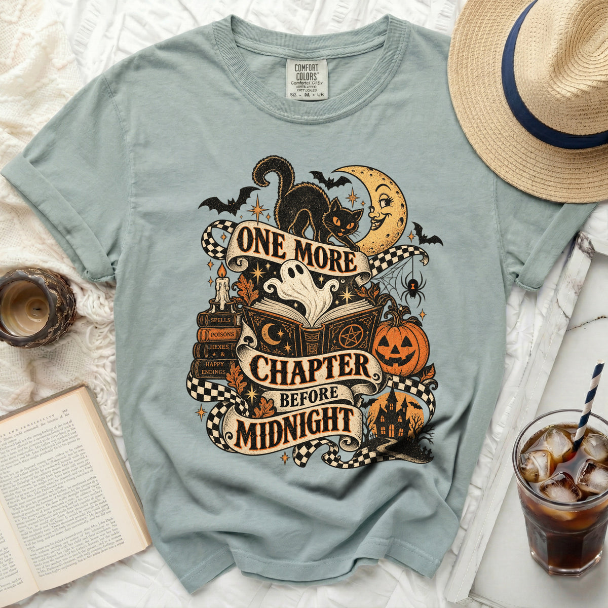 Light blue t-shirt with "One More Chapter Before Midnight" Halloween graphic.