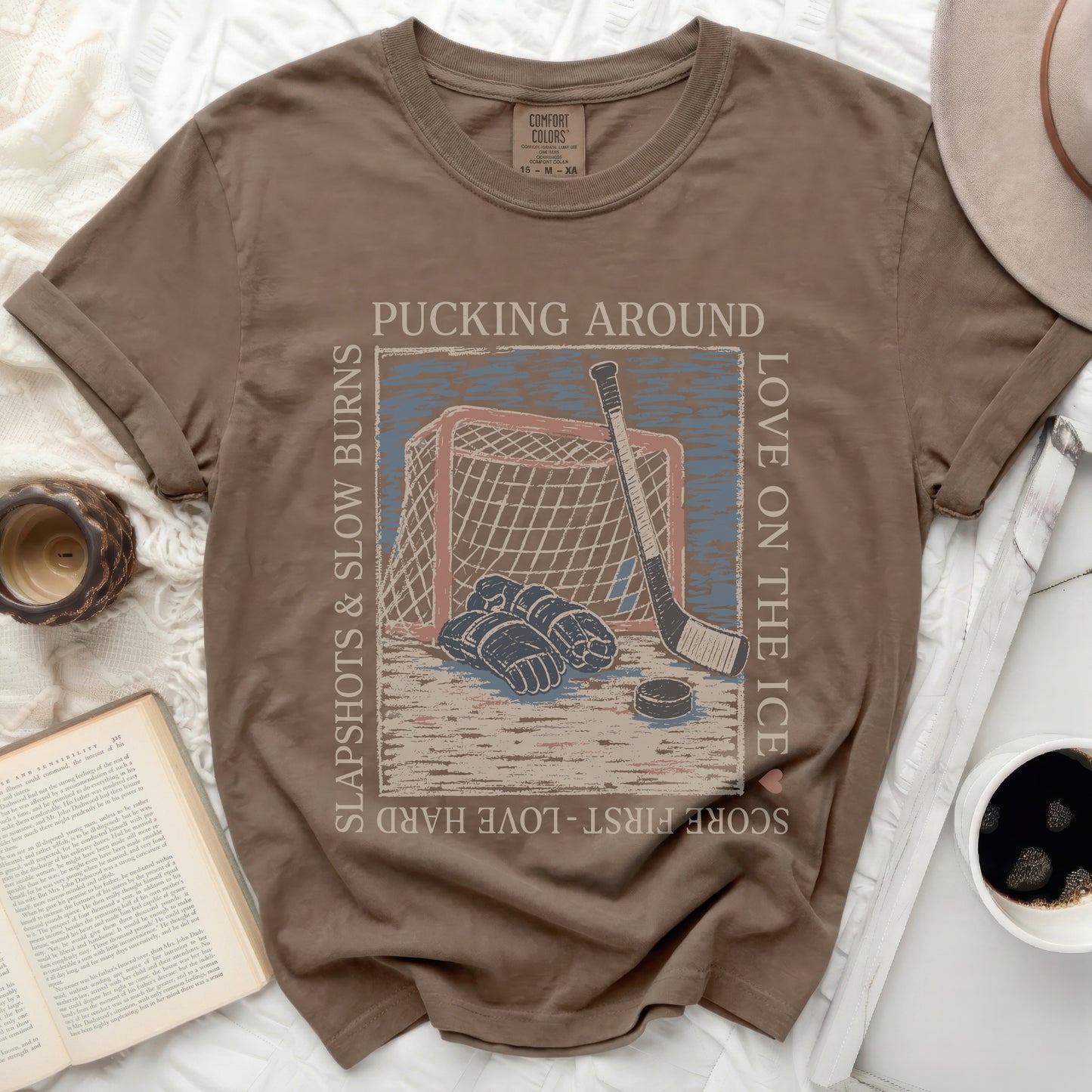 T-shirt with hockey puck, stick, net, and text "Pucking Around" and "Love on the Ice."