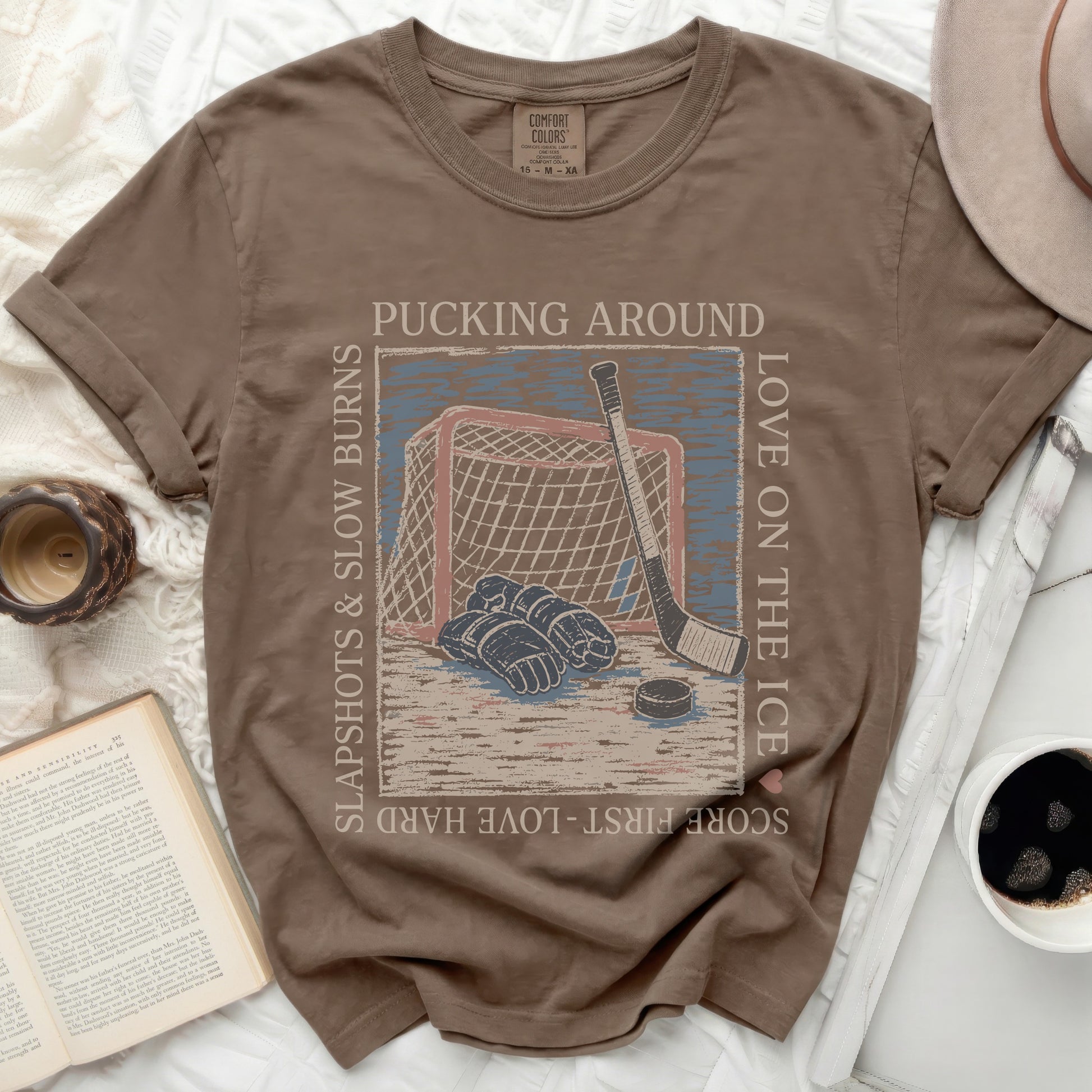 T-shirt with hockey puck, stick, net, and text "Pucking Around" and "Love on the Ice."