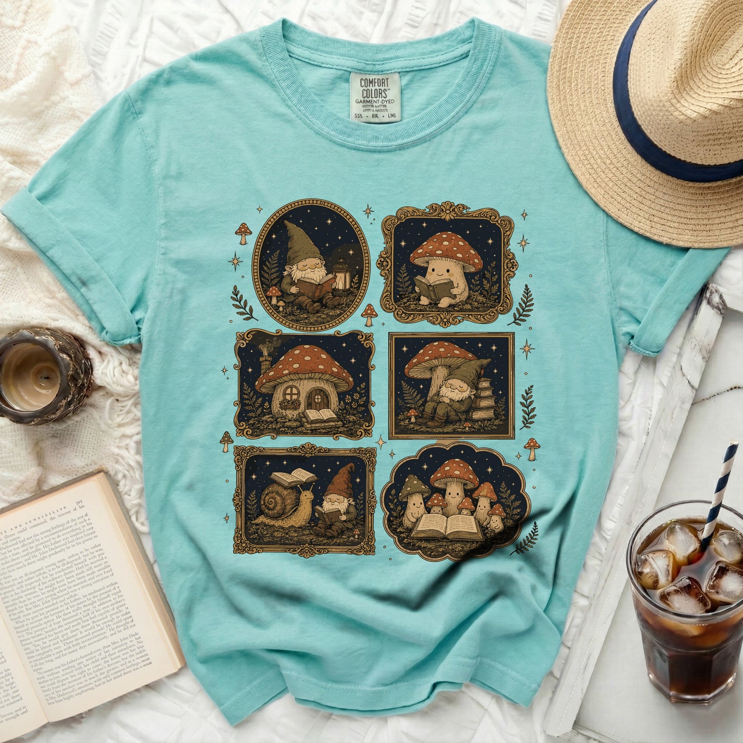 Teal t-shirt with five framed illustrations of gnomes and mushrooms reading books.