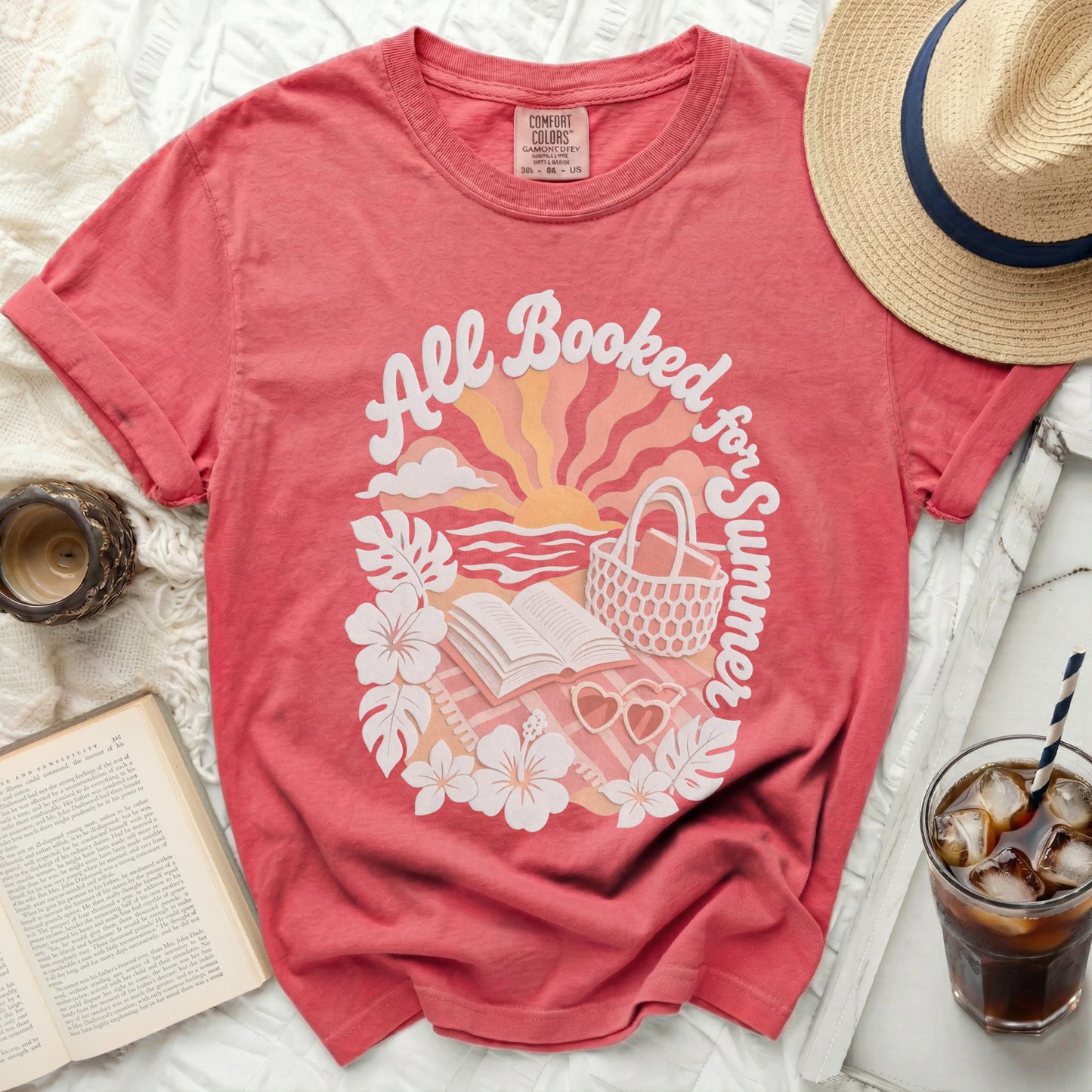 Coral t-shirt with "All Booked for Summer" graphic featuring books and beach elements.