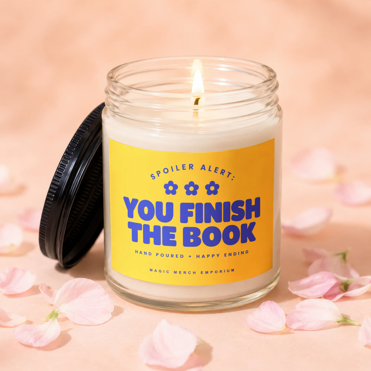 Lit candle with yellow label reading "Spoiler Alert: You Finish The Book."