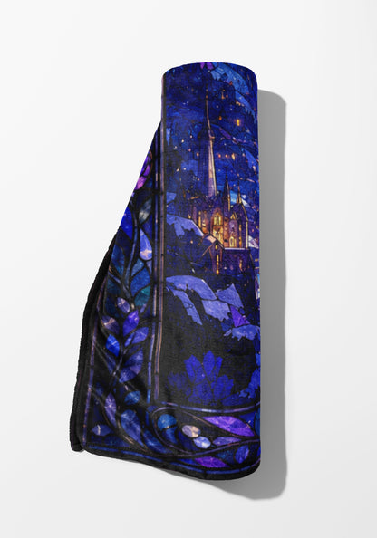 Rolled blanket with stained glass design of a castle at night.