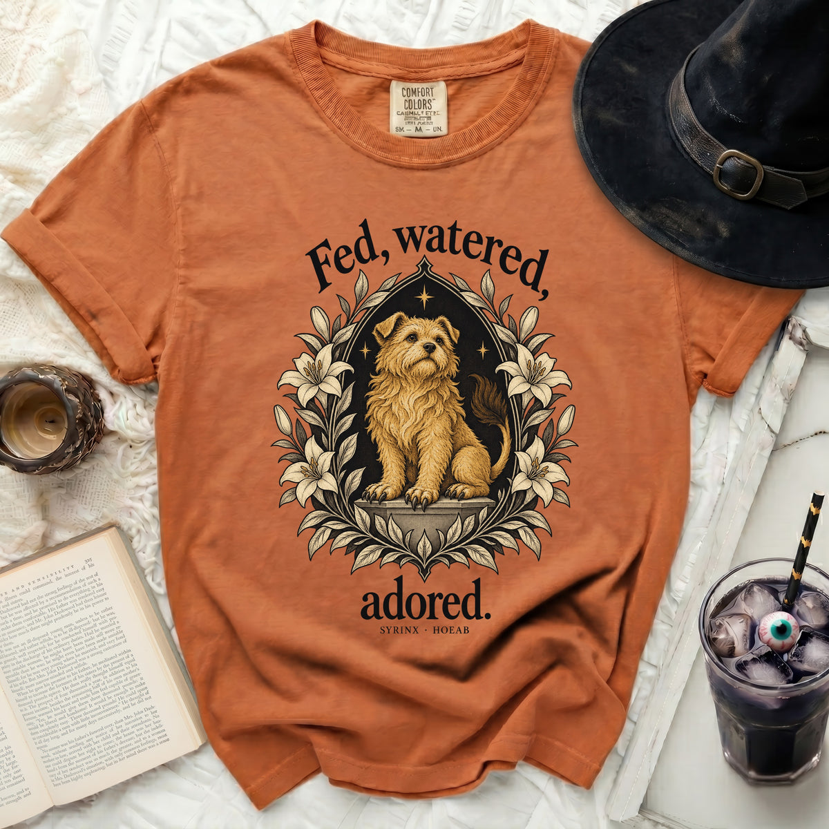 Orange t-shirt with "Fed, watered, adored." and dog graphic.