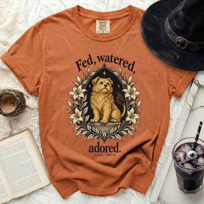 Orange t-shirt with "Fed, watered, adored." and dog graphic.