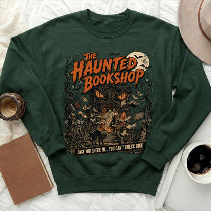 Green sweatshirt with vintage "The Haunted Bookshop" graphic featuring a haunted house, ghost, cat, and bats.