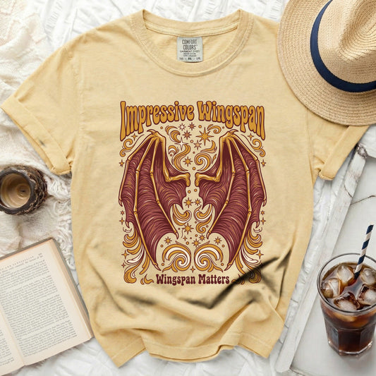 Yellow t-shirt with "Impressive Wingspan" and bat wings graphic.