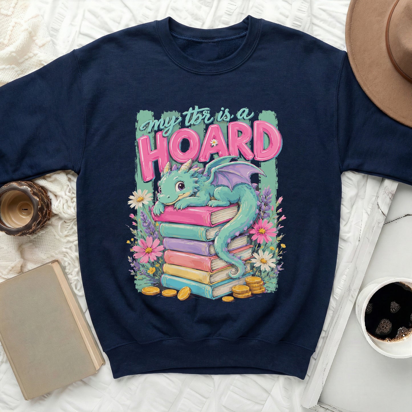 Navy sweatshirt with a graphic of a teal dragon on stacked books and text 'my tbr is a hoard'.