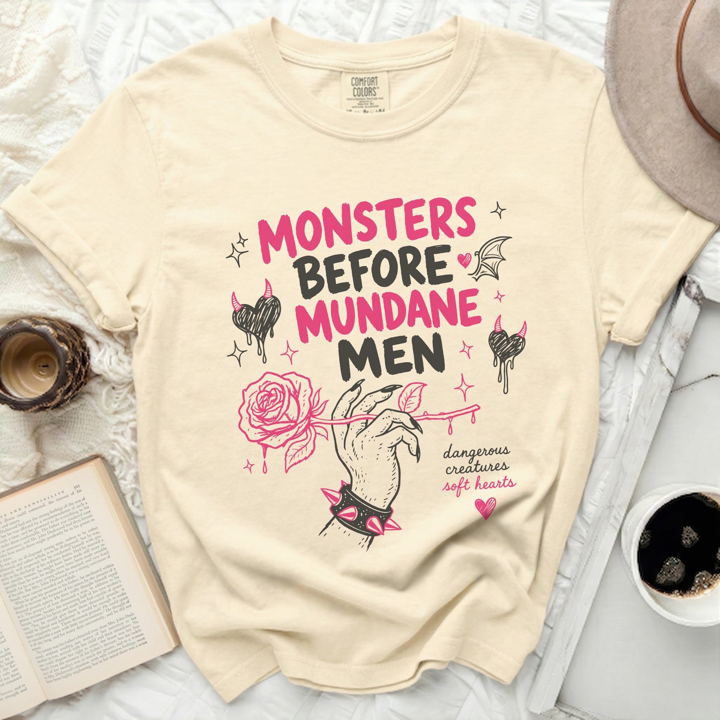 Cream t-shirt with pink "Monsters Before Mundane Men" text and rose illustration.