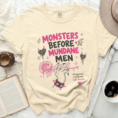 Cream t-shirt with pink "Monsters Before Mundane Men" text and rose illustration.