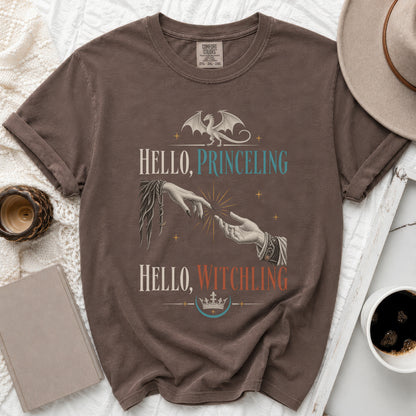 Brown t-shirt with "Hello, Princeling" and "Hello, Witchling" text, dragon, and hands.