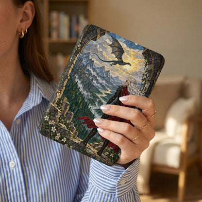 Woman holding a tablet with a dragon, mountains, and castle scene.