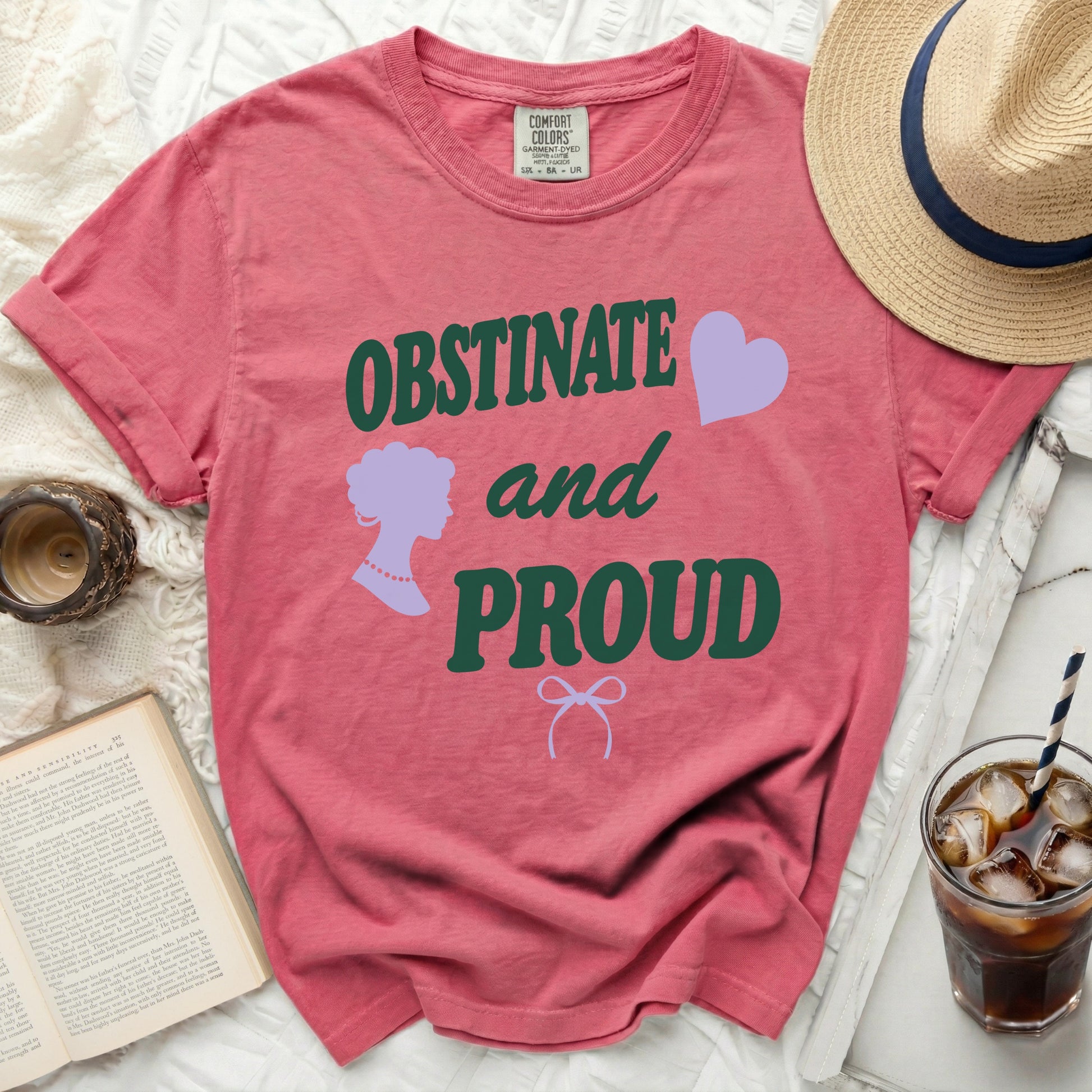 Salmon pink t-shirt with "OBSTINATE and PROUD" text, silhouette, and heart.