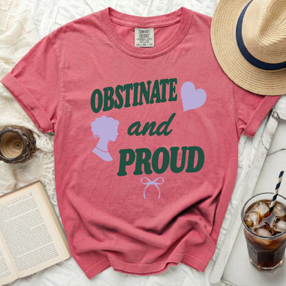 Salmon pink t-shirt with "OBSTINATE and PROUD" text, silhouette, and heart.