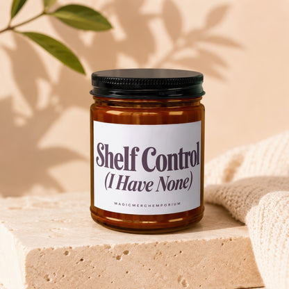 Amber jar candle, black lid, white label stating "Shelf Control (I Have None)".
