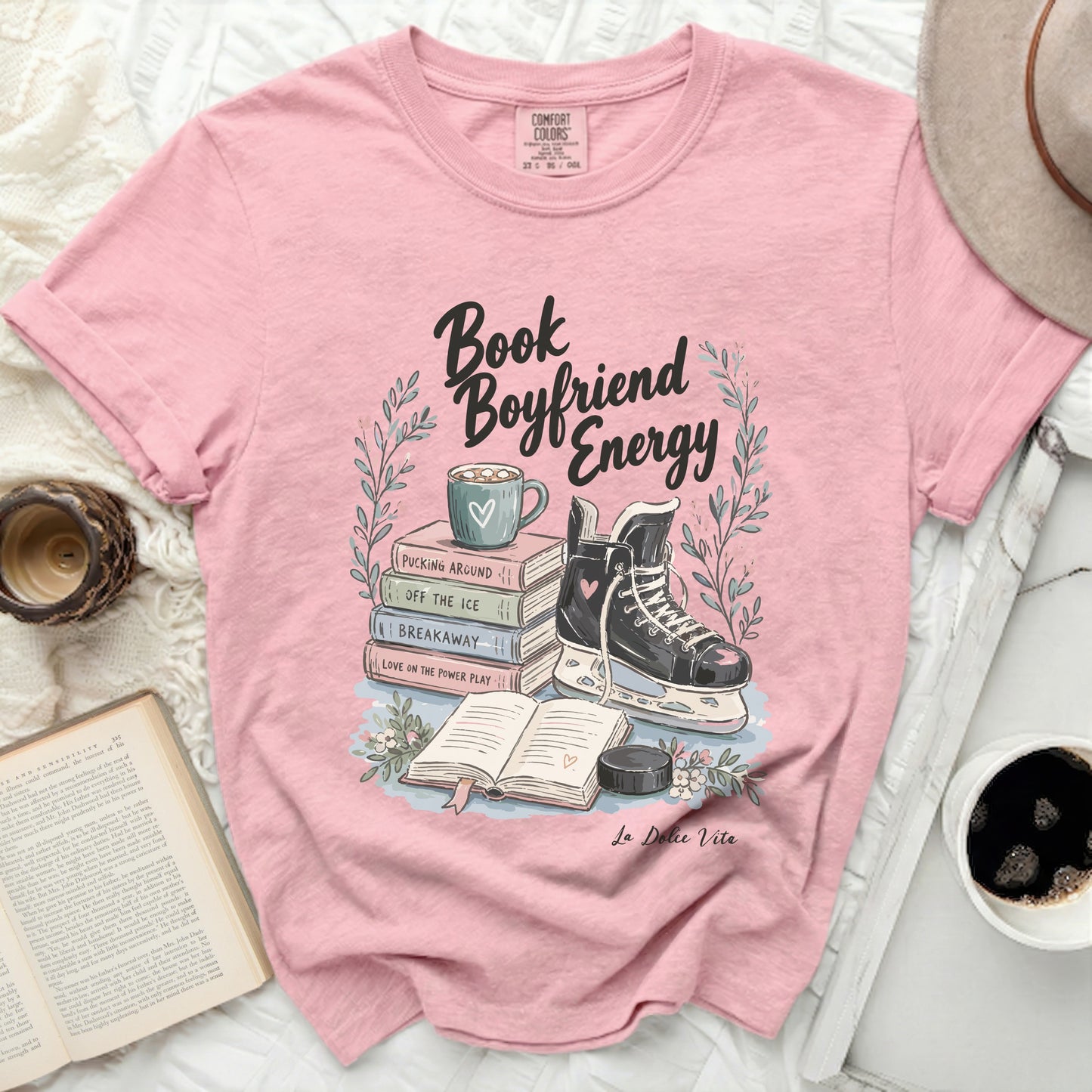 Pink t-shirt with "Book Boyfriend Energy" text, ice skate, and books.