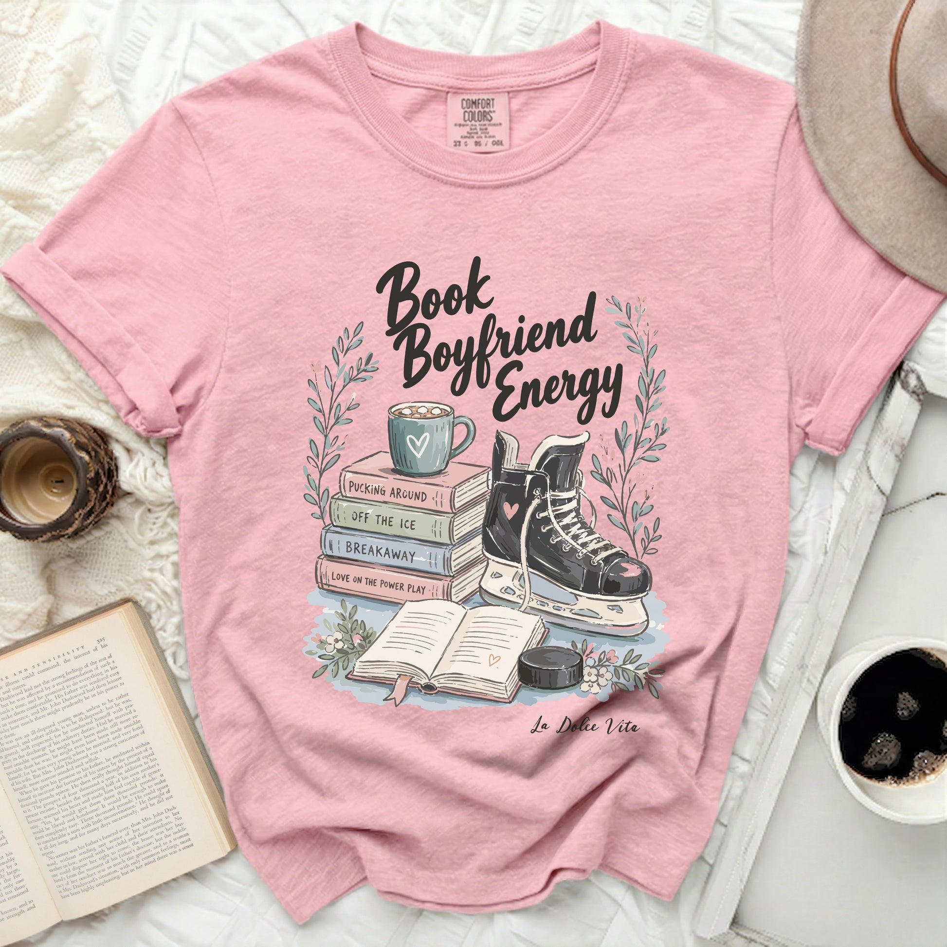 Pink t-shirt with "Book Boyfriend Energy" text, ice skate, and books.