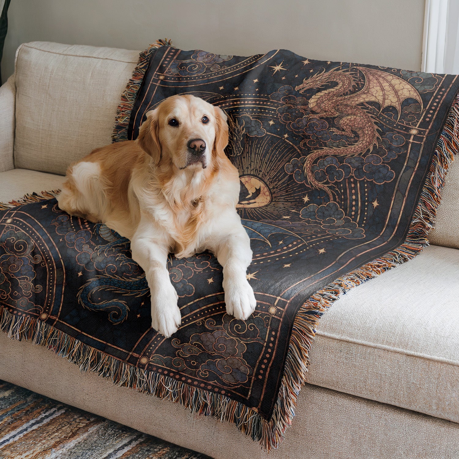 A golden retriever dog is sitting on a couch, resting on a decorative blanket with a dragon design.