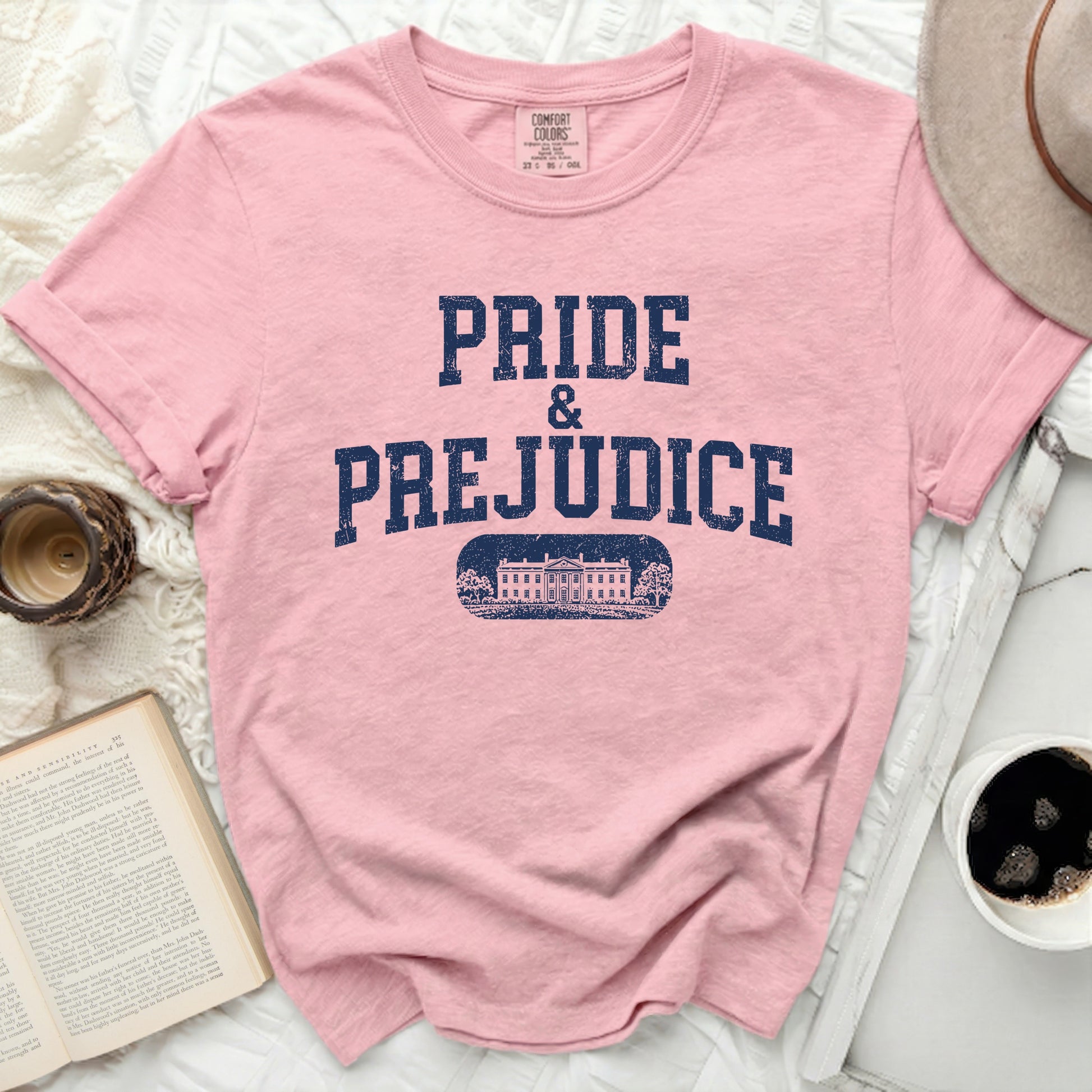 Pink t-shirt with "Pride & Prejudice" text and a building graphic.
