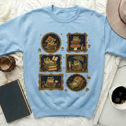 Light blue sweatshirt featuring a collage of illustrated frogs reading books and mugs.