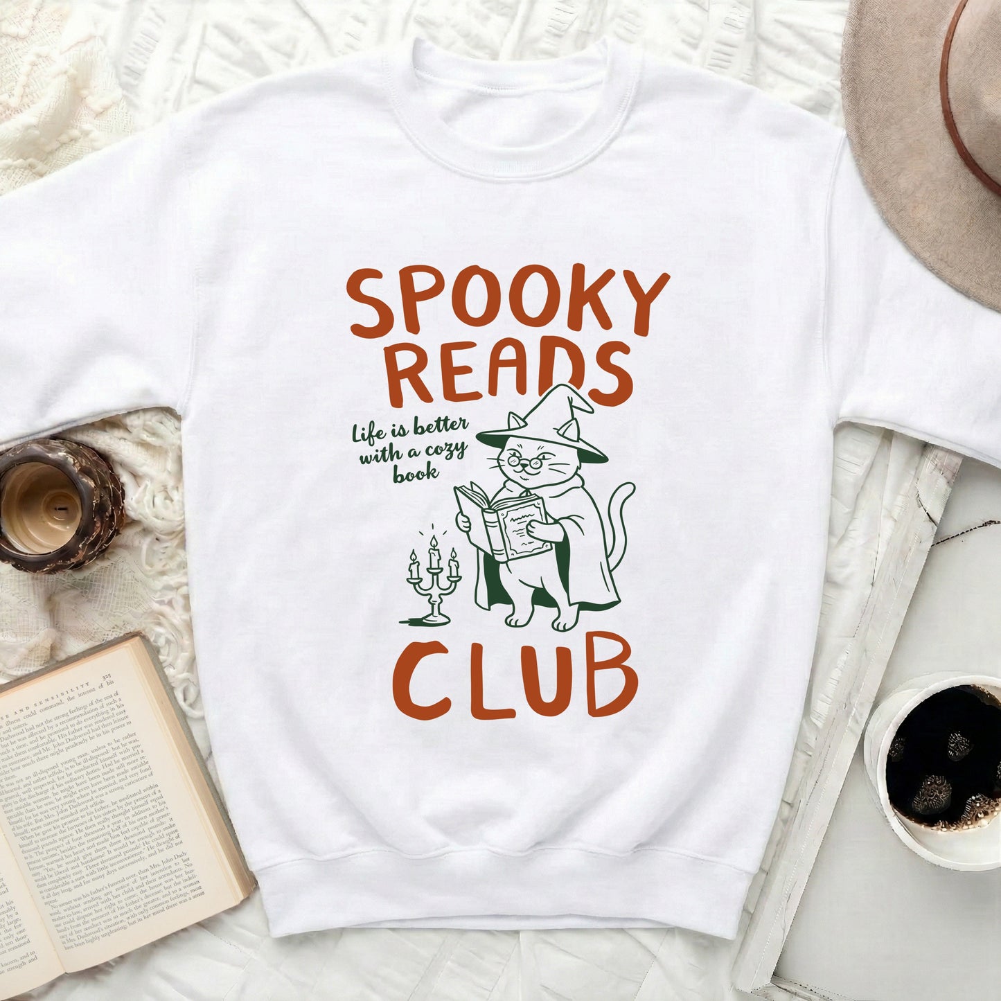 White sweatshirt with "Spooky Reads" text and witch cat.