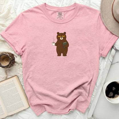 Pink t-shirt with a cartoon bear holding coffee and a book.